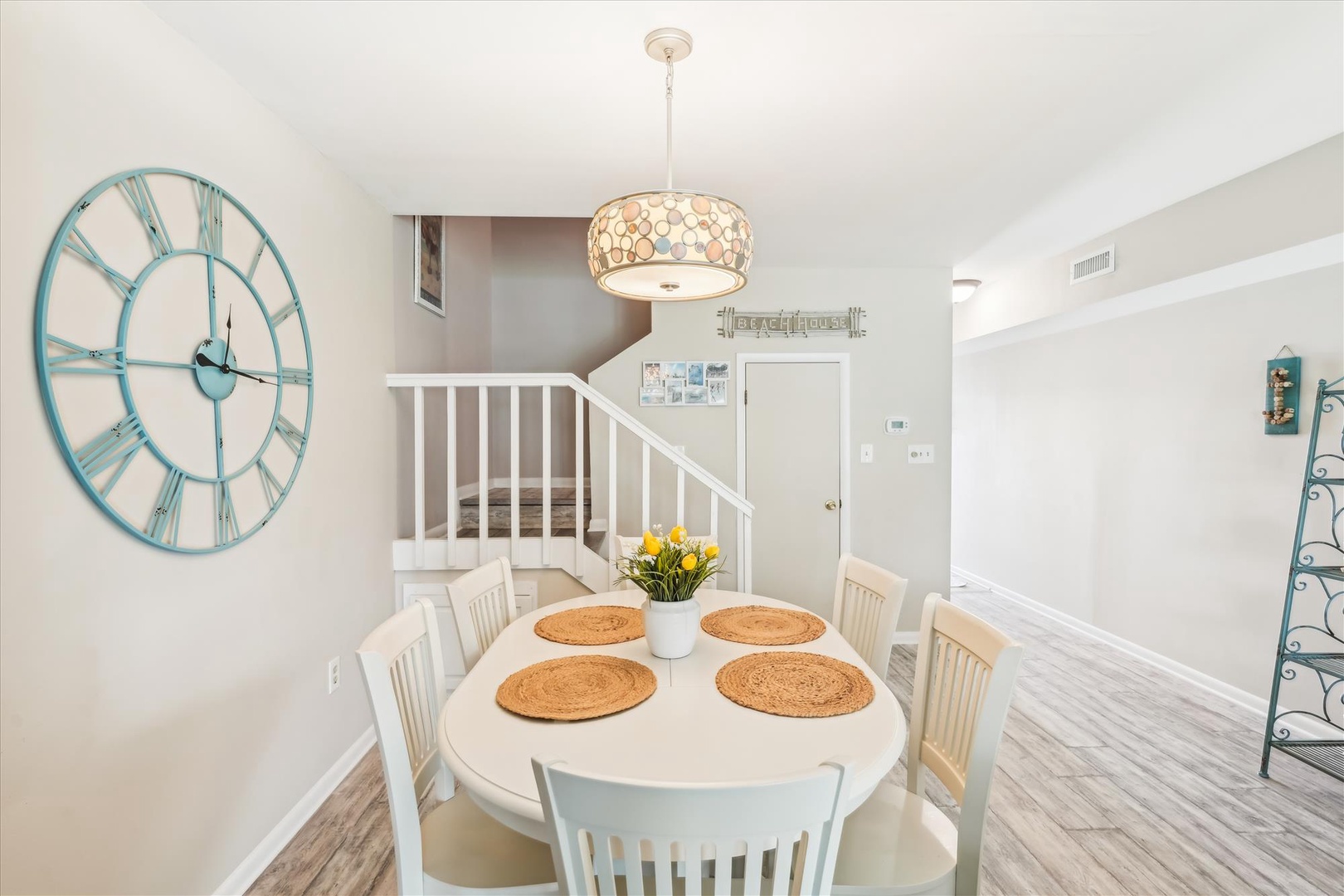 Gather around this charming dining table where your group can share memorable meals together beneath elegant pendant lighting.