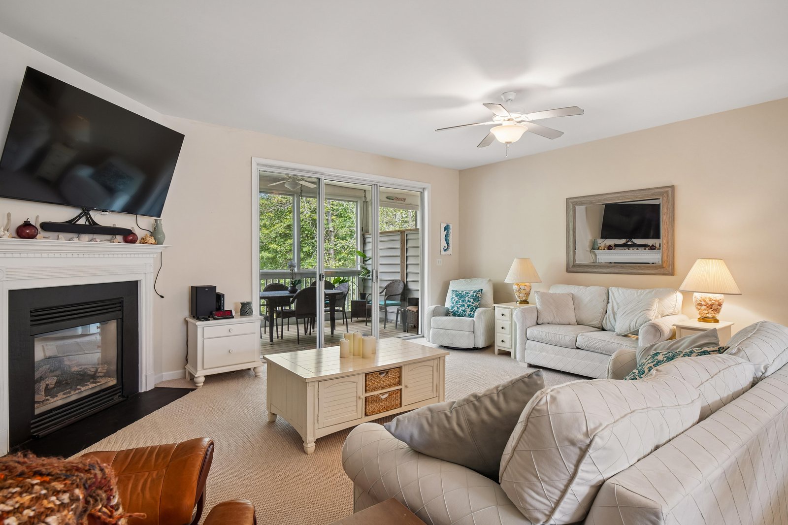 Sink into plush sofas in your bright, inviting living room, where coastal touches and a cozy fireplace create your perfect retreat after exploring nearby beaches.