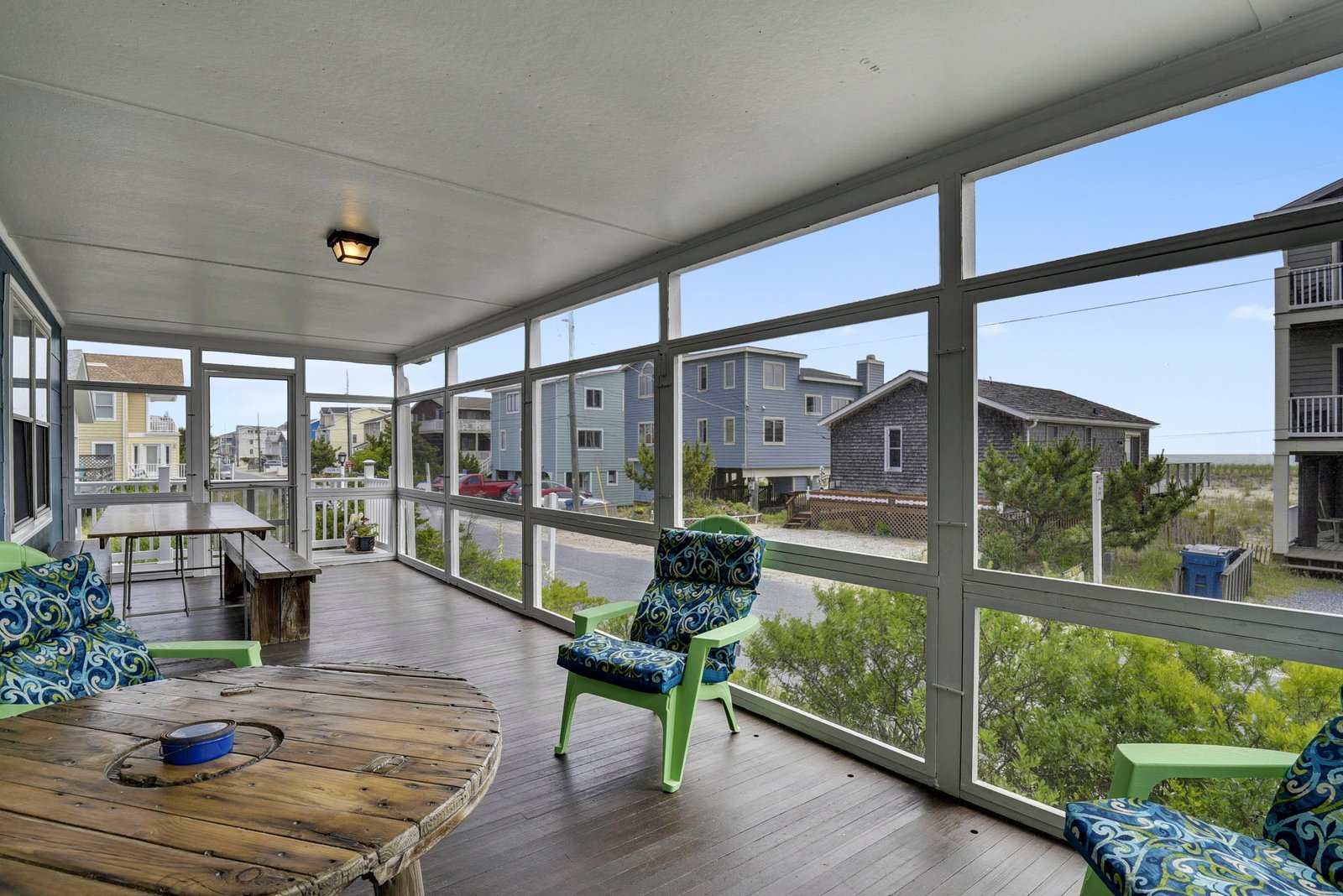 Relax in your private screened porch with coastal breezes and partial beach views, surrounded by comfortable seating and natural light—a perfect retreat after a day by the shore.