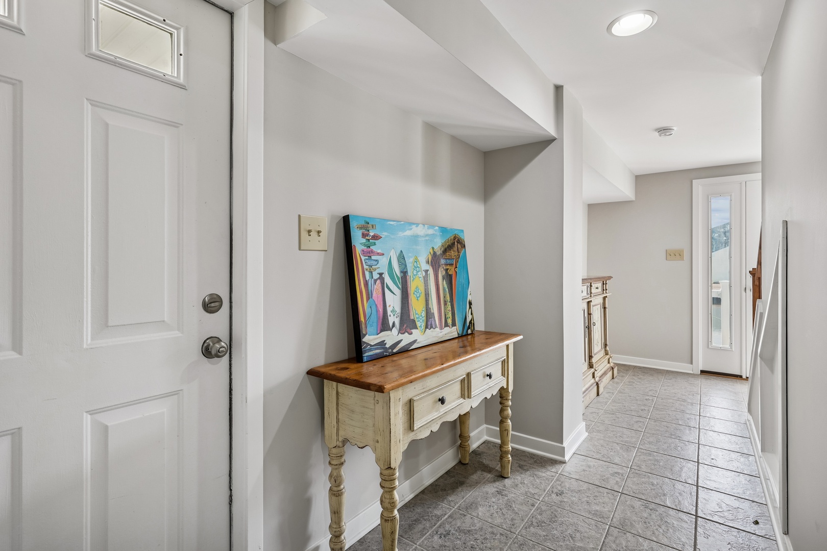 Step into your welcoming entryway where charming coastal artwork and rustic furnishings create the perfect beach house atmosphere for your getaway.