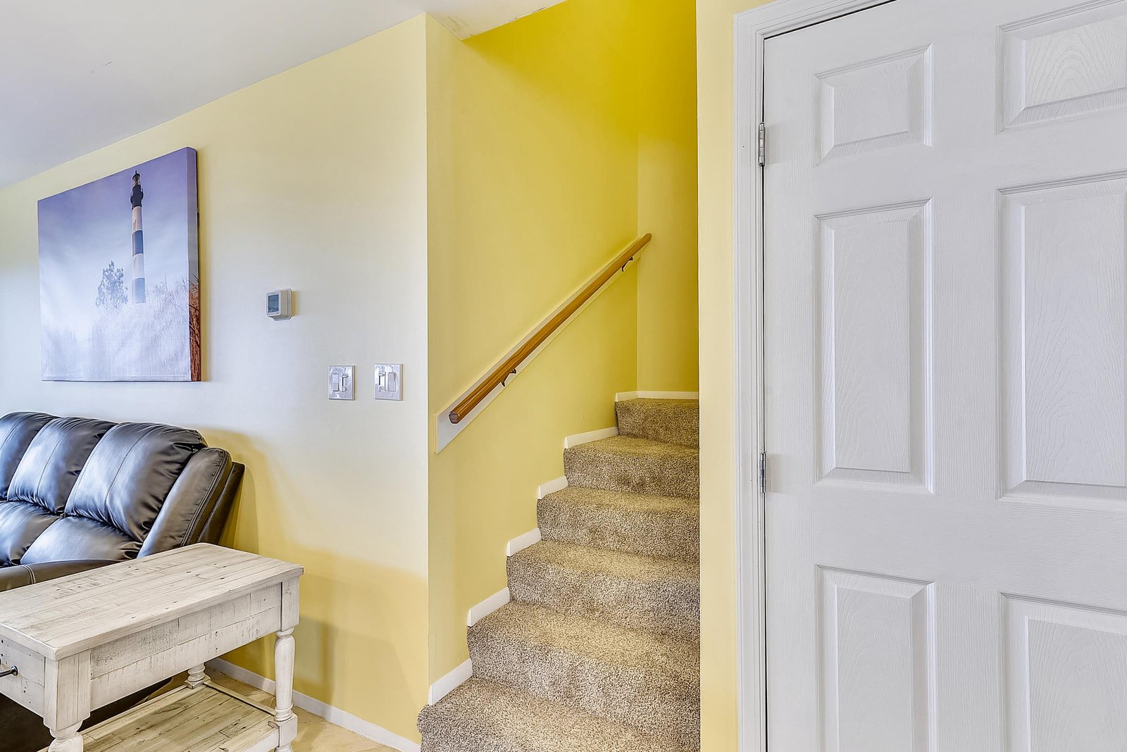 Bright and cheerful living space with stairs leading to your upstairs retreat. Relax on the cozy sofa or explore the upper level.