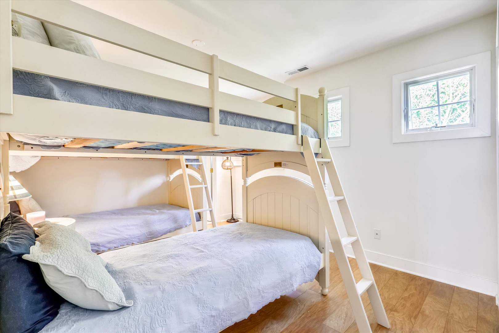 Perfect for families, this bright bedroom features bunk beds with a cozy lower full-size bed and reading lights. Natural light fills the room, creating a cheerful space where your kids or guests can rest comfortably.