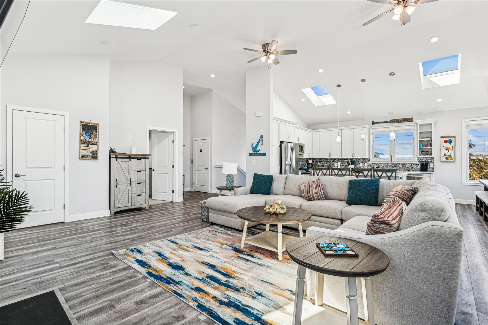Relax in your bright, airy living room with soaring ceilings, skylights, and plush seating. The open layout flows seamlessly into the modern kitchen, perfect for gathering.