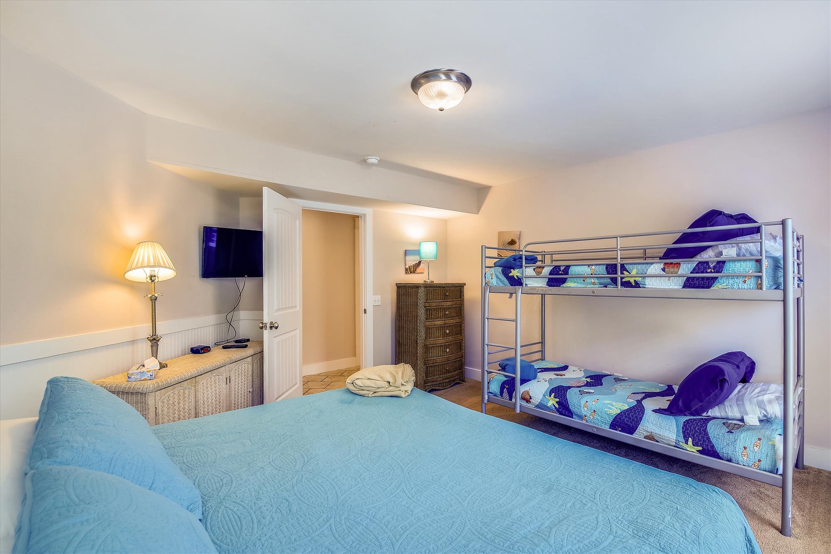 Your spacious bedroom sleeps the whole family with a comfy queen bed and fun bunk beds. Soft lighting, a mounted TV, and cozy décor create a perfect retreat after a day of exploring.