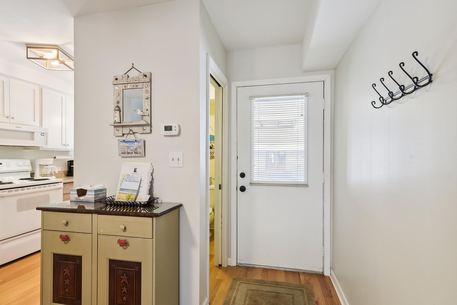 Step inside to find a welcoming entryway with warm wood floors that lead you into your cozy retreat, complete with charming details and easy access to the bright kitchen.