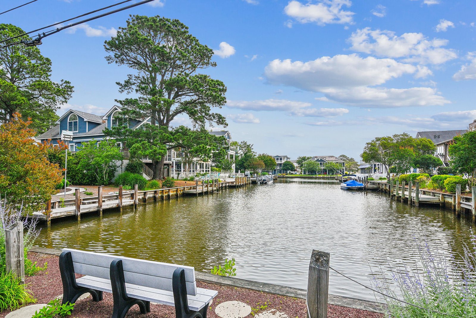 The property is situated in a tranquil waterfront neighborhood with private docks and a peaceful canal winding through lush greenery.