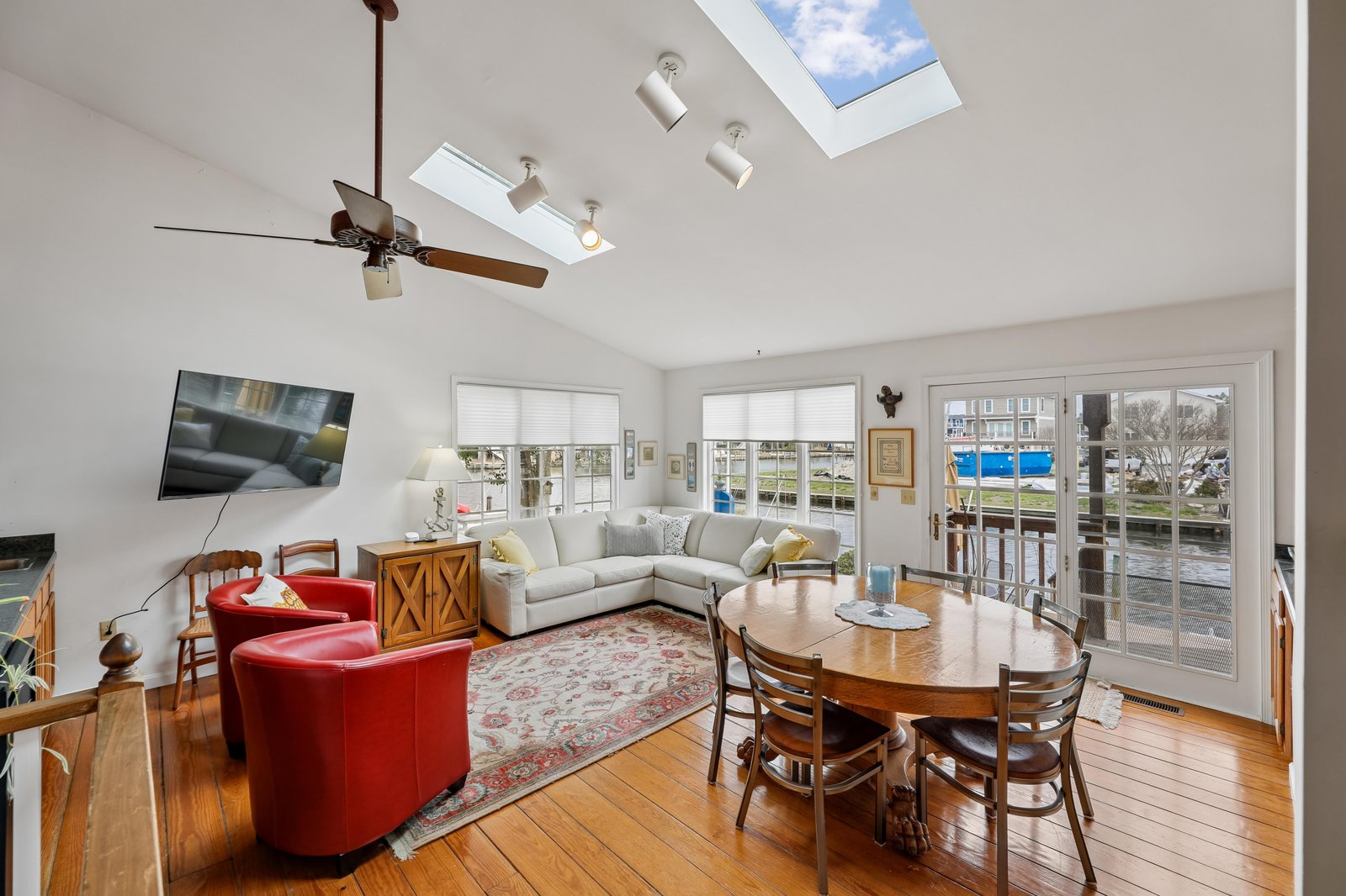 Gather around the dining table or sink into the plush sectional in this bright, open living space. Vaulted ceilings with skylights flood the room with natural light, while French doors open to your outdoor escape.