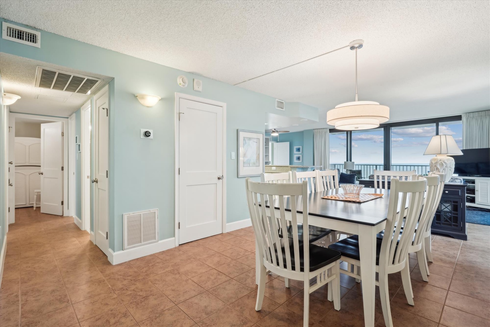 Gather around your elegant dining table with ocean views as your backdrop, creating memorable meals in this coastal-inspired space.
