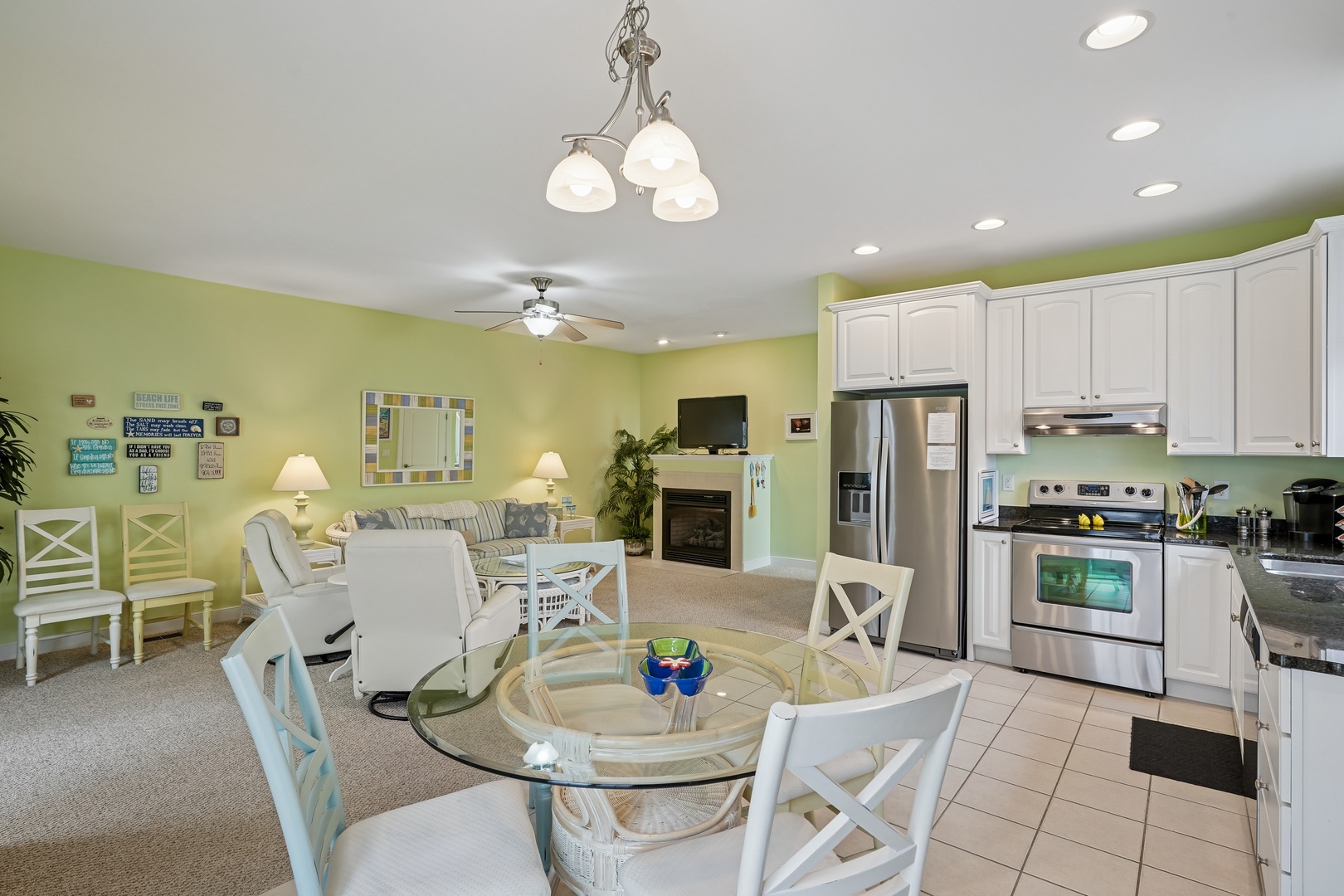 Step into your bright open-concept living space where coastal charm meets modern comfort with cheerful green walls and elegant white furnishings.