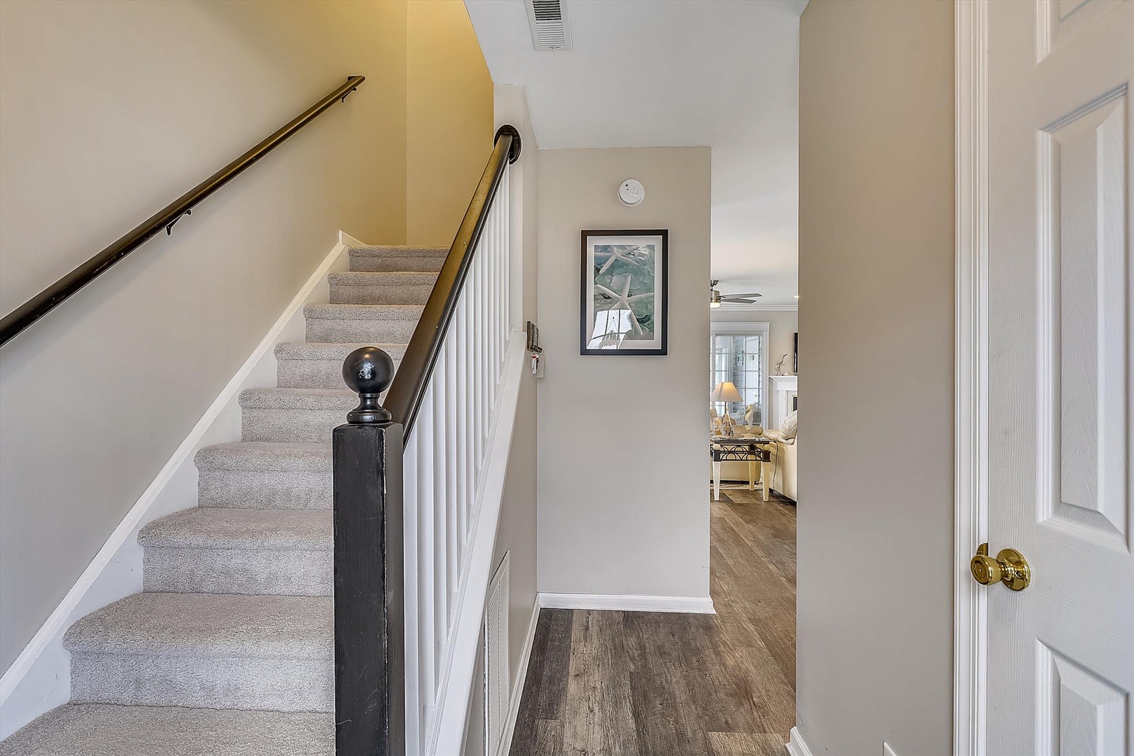 Bright entryway with elegant wood stairs leading to your private upstairs bedrooms, setting a warm and welcoming tone the moment you arrive.