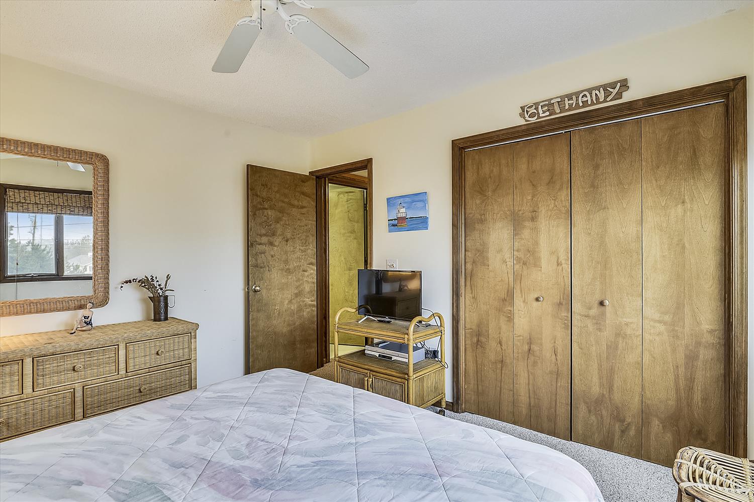 Your cozy bedroom features a comfy bed with soft linens, ample wardrobe space for unpacking, and thoughtful touches like a ceiling fan to keep you cool and a personal TV stand for evening relaxation.