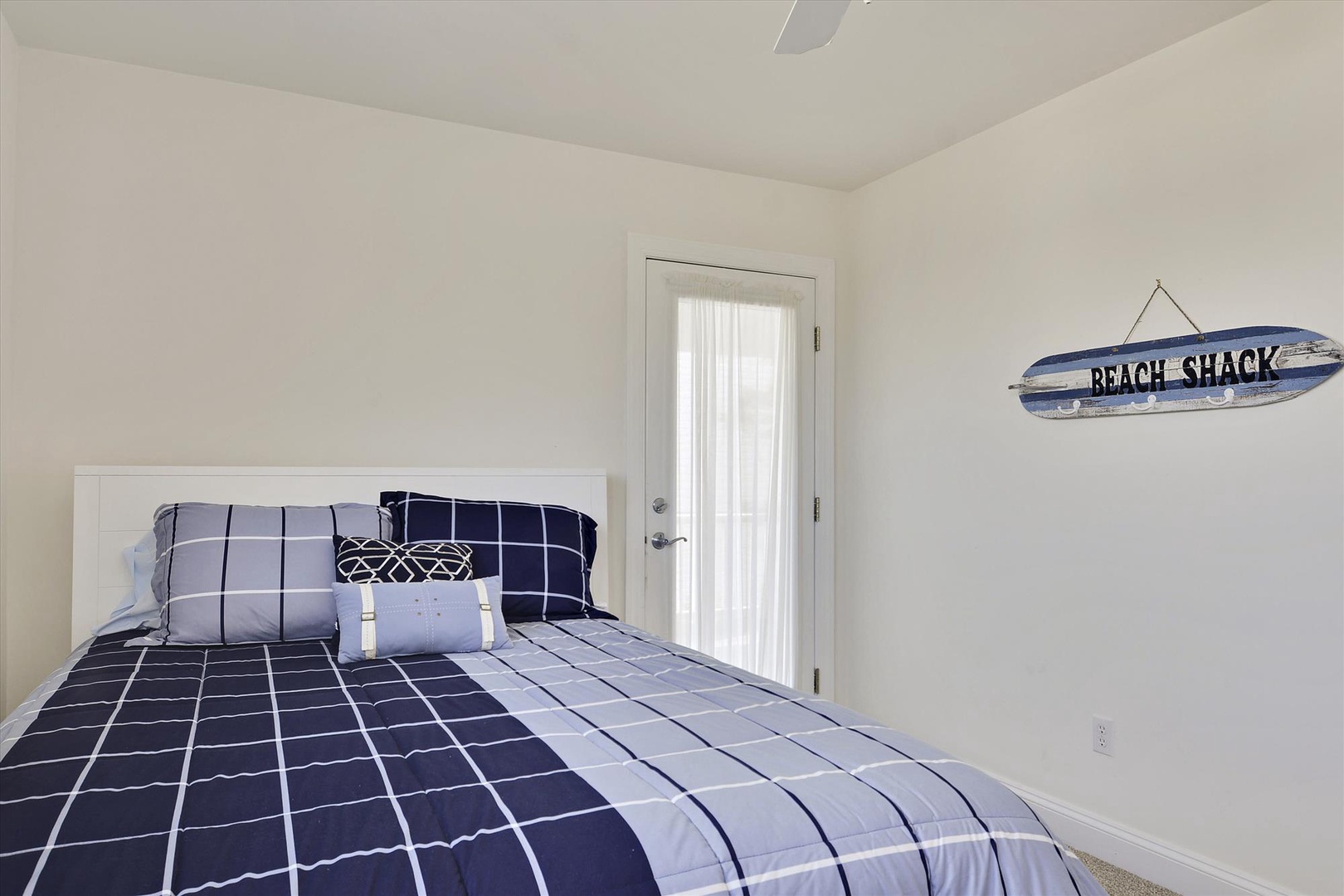 Your cozy bedroom features crisp navy linens and charming beach decor, creating the perfect coastal retreat for restful nights.