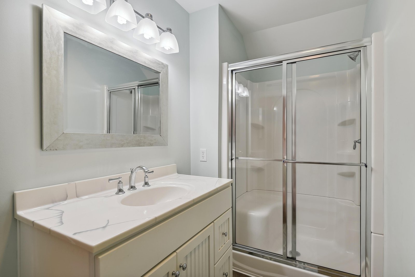Step into a spotless bathroom with fresh white fixtures, a soft vanity light, and a roomy glass shower—your personal retreat after a day of exploring.