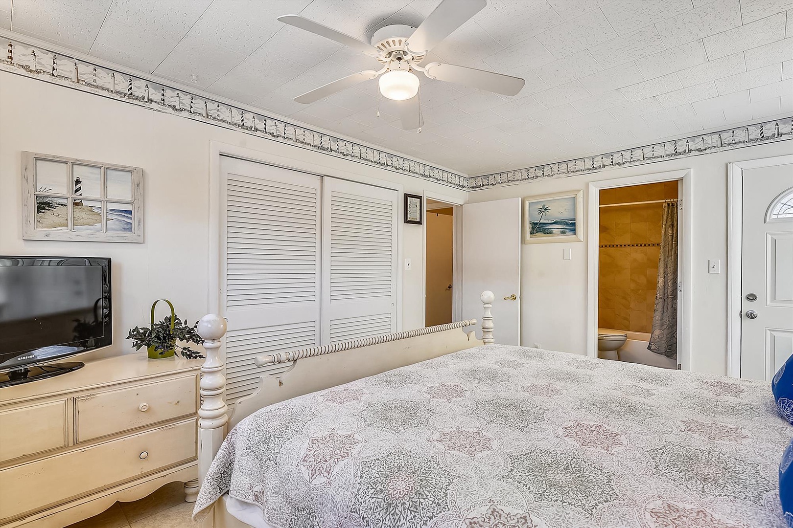 Relax in your bright, comfortable bedroom with a plush bed, ceiling fan, TV, and direct access to your private en-suite bathroom for ultimate convenience.