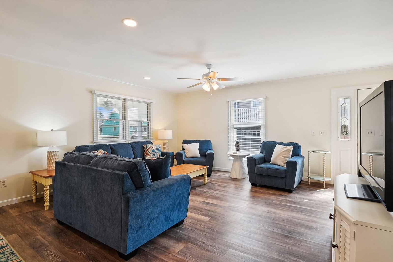 Sink into plush blue sofas and unwind in your spacious living room, where natural light and coastal breezes fill the space with a calm, welcoming vibe.