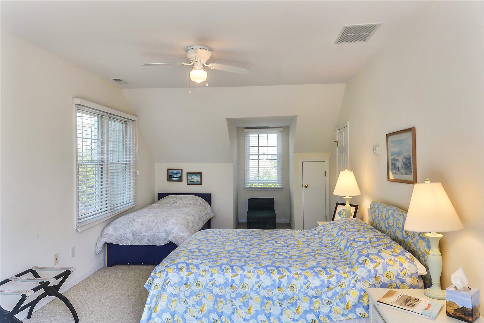 Your peaceful guest room features two comfortable beds, soft natural light, and gentle ceiling fan comfort—perfect for relaxing after a day of exploring.