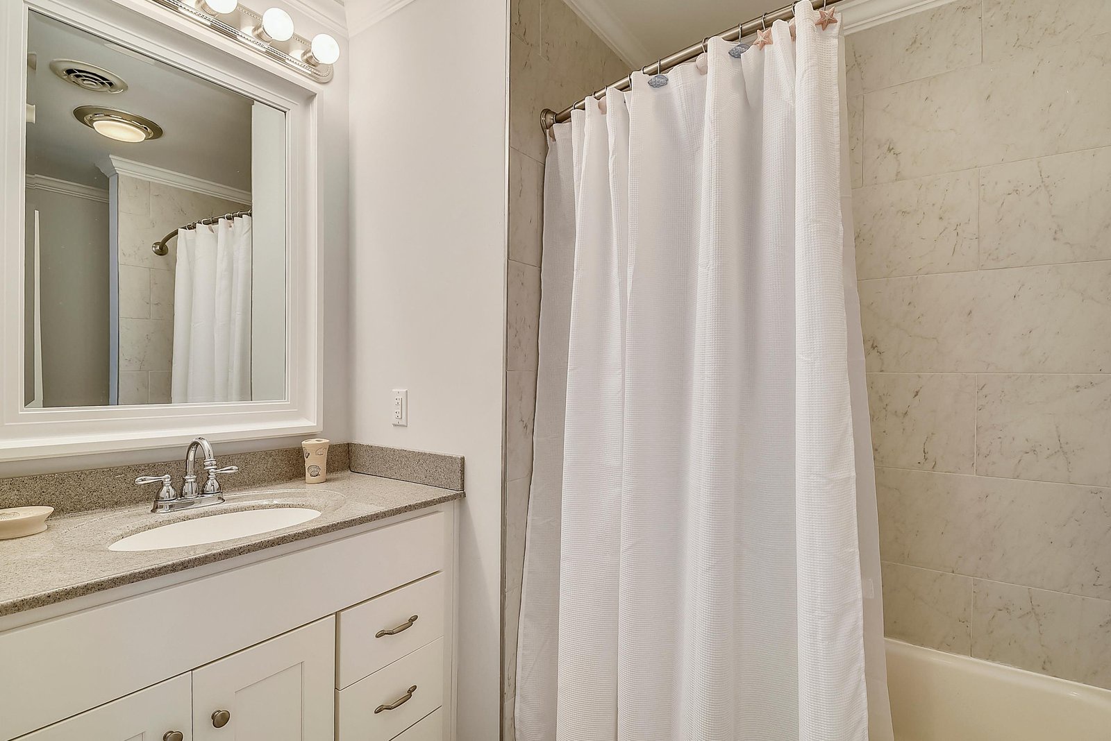 Refresh in your private bathroom, featuring soft lighting, elegant tile, and fresh towels awaiting your arrival.