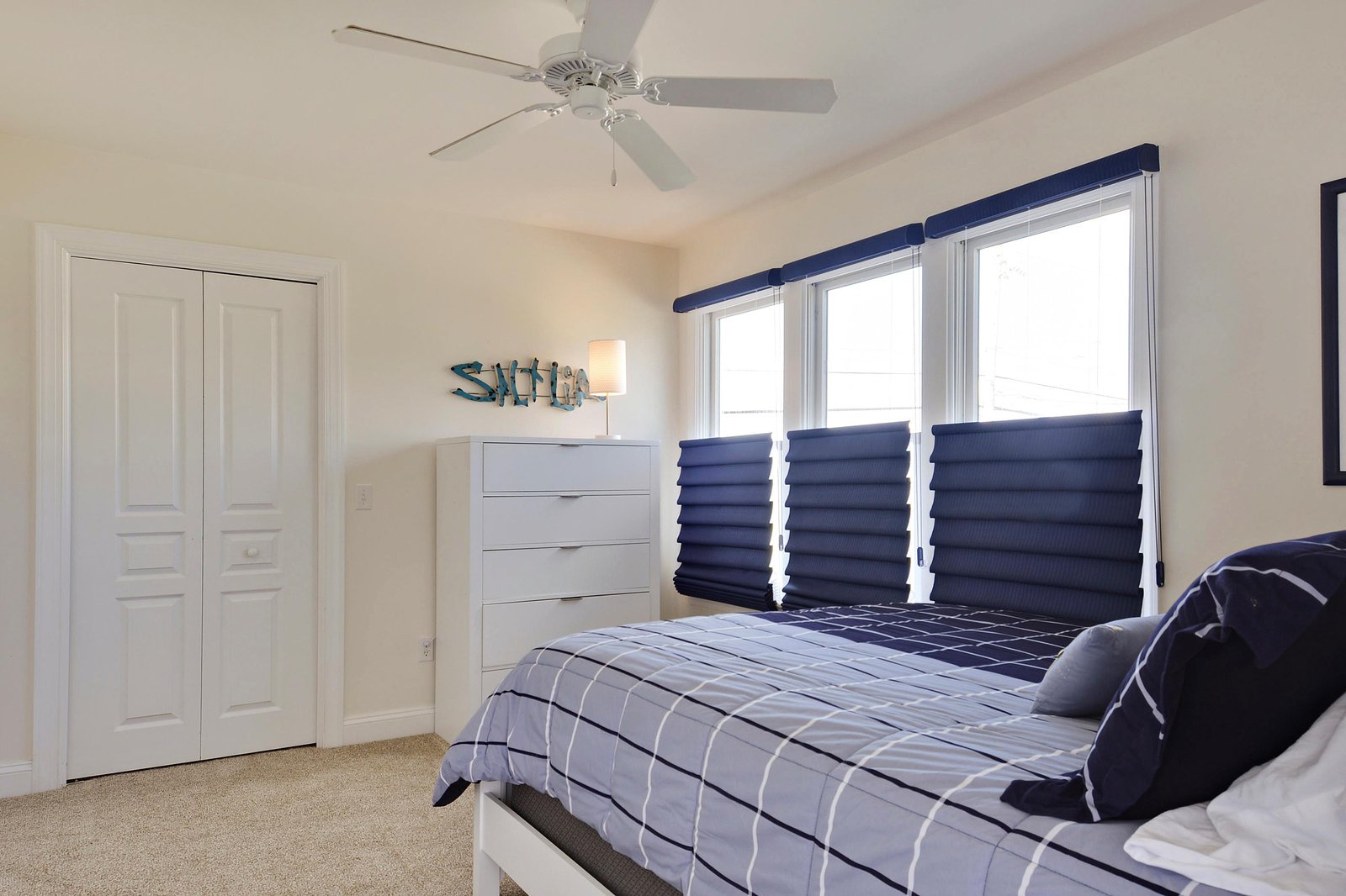 Your bright, airy bedroom features a ceiling fan, plush carpeting, and ample closet space for relaxing after a day at the beach.