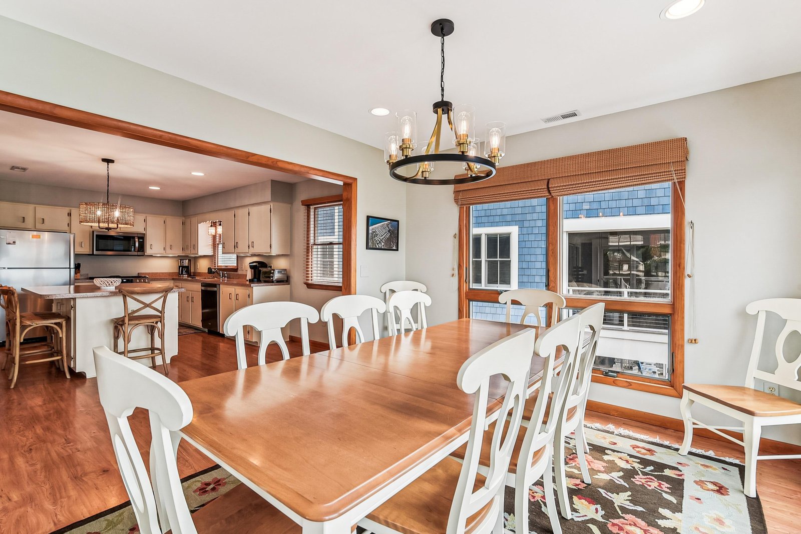 Gather around this spacious dining table bathed in natural light from generous windows, with a gleaming kitchen just steps away—ready for your shared meals and laughter.