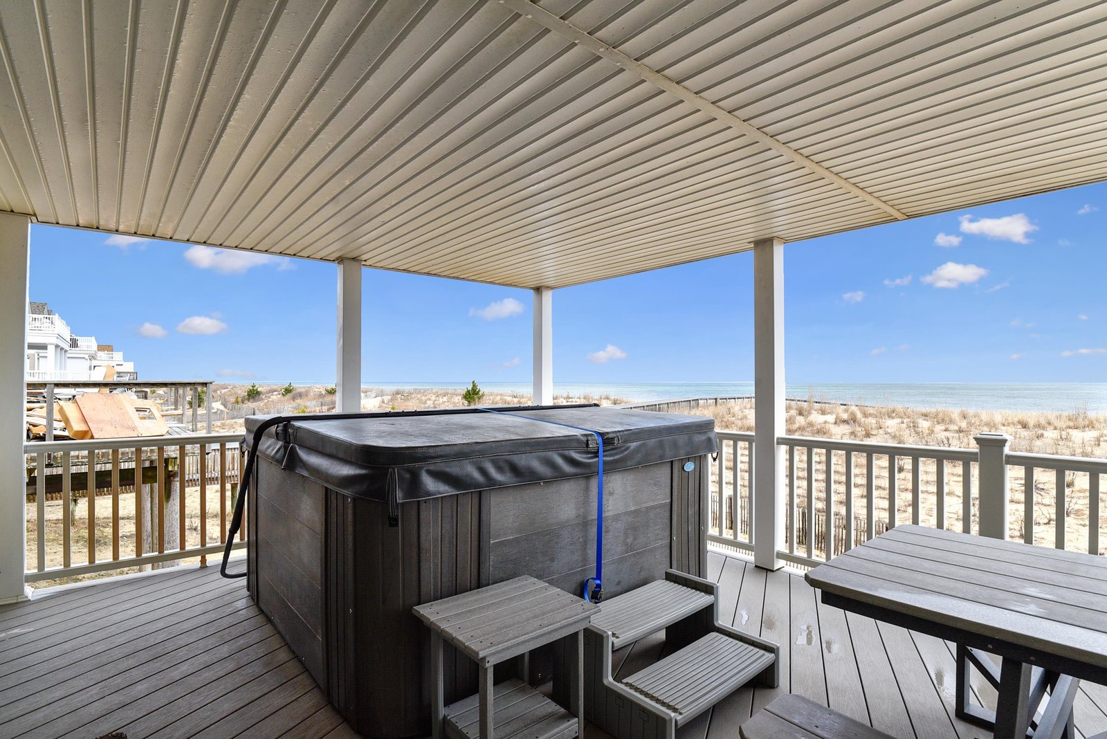 Step outside to your covered deck with a private hot tub overlooking the beach and dunes. Perfect for soaking under the sky after a day by the water.