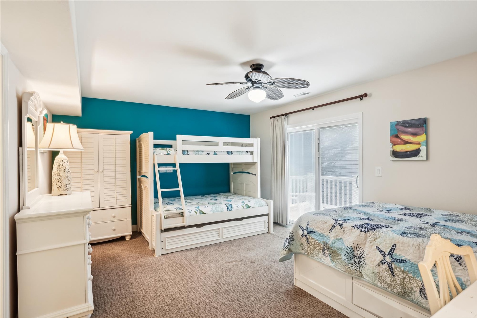 Your family can spread out comfortably in this coastal-themed bedroom with a bunk bed and a separate queen bed, all while enjoying ocean-inspired details and a private balcony.