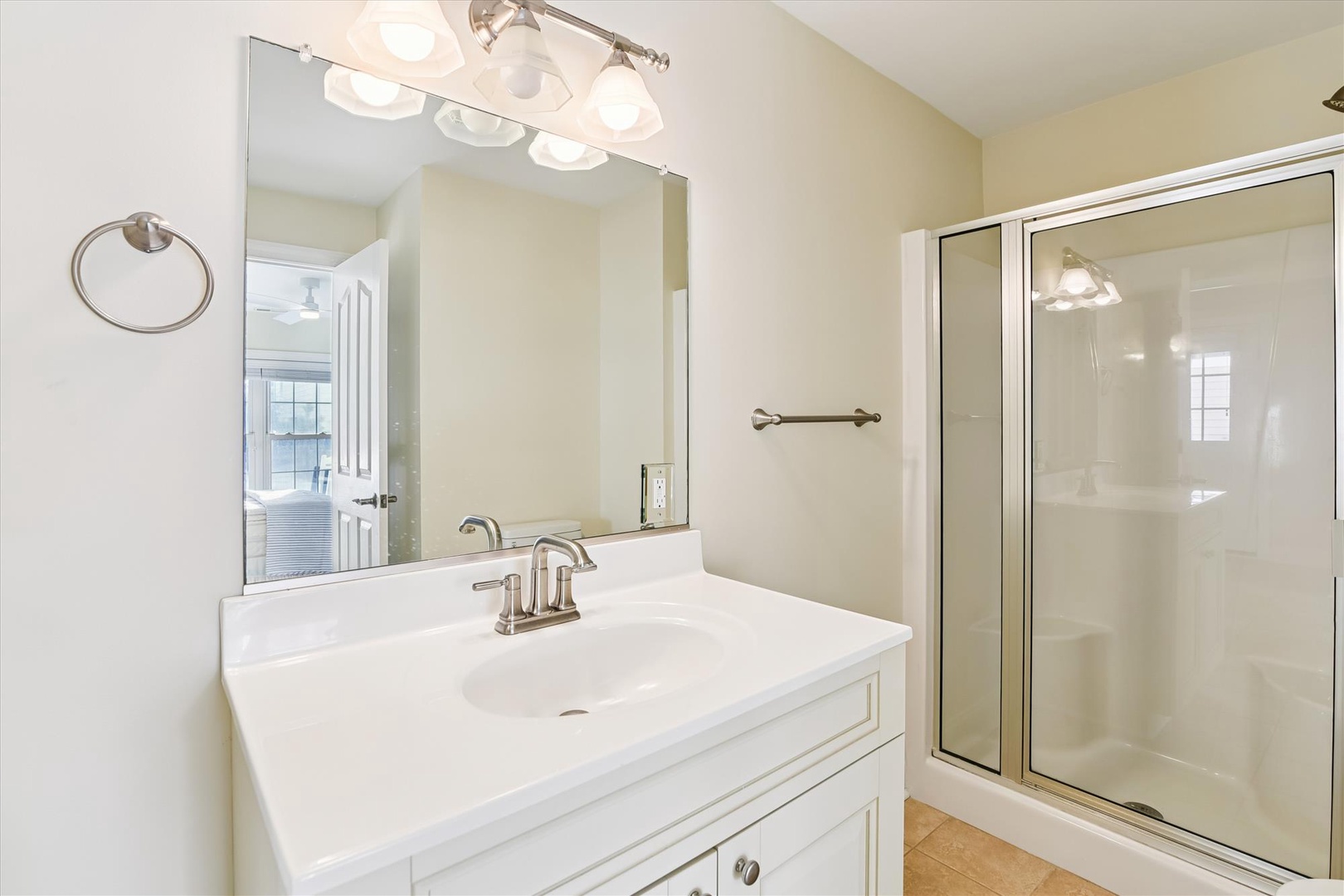 Freshen up in your private bathroom with a bright vanity, modern fixtures, and a sparkling glass-enclosed shower ready for your morning routine.