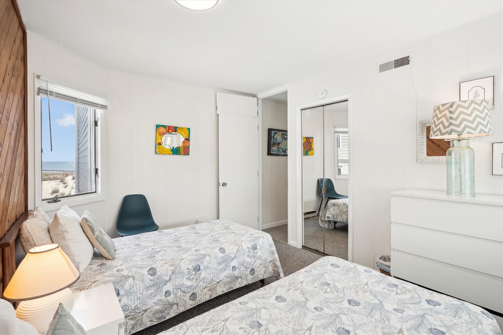 Drift off in this bright, airy bedroom with soothing coastal views and twin beds dressed in soft, beachy linens—your perfect retreat after a day of adventure.