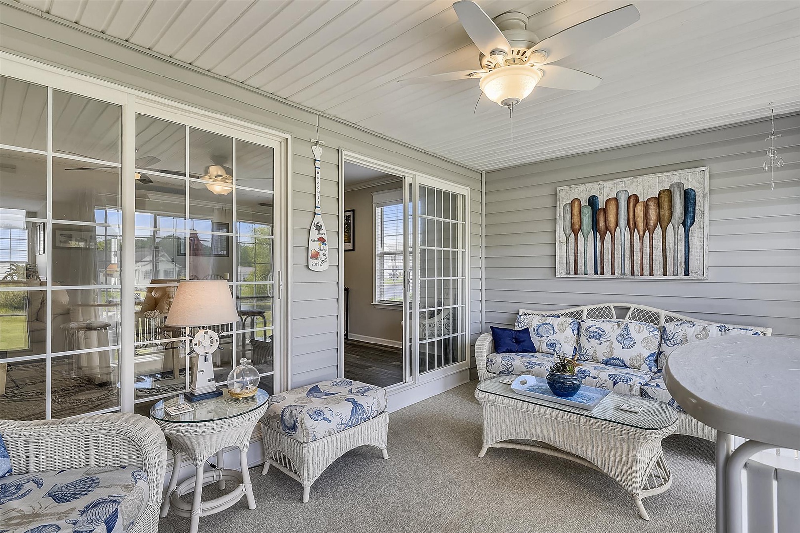 Your private screened porch invites you to unwind with coastal-inspired seating, soft lighting, and peaceful views—perfect for morning coffee or evening relaxation.