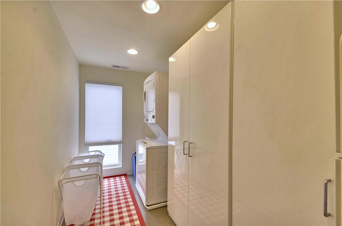A dedicated laundry room with stacked washer and dryer, ample storage, and bright lighting keeps your vacation wardrobe fresh and ready.
