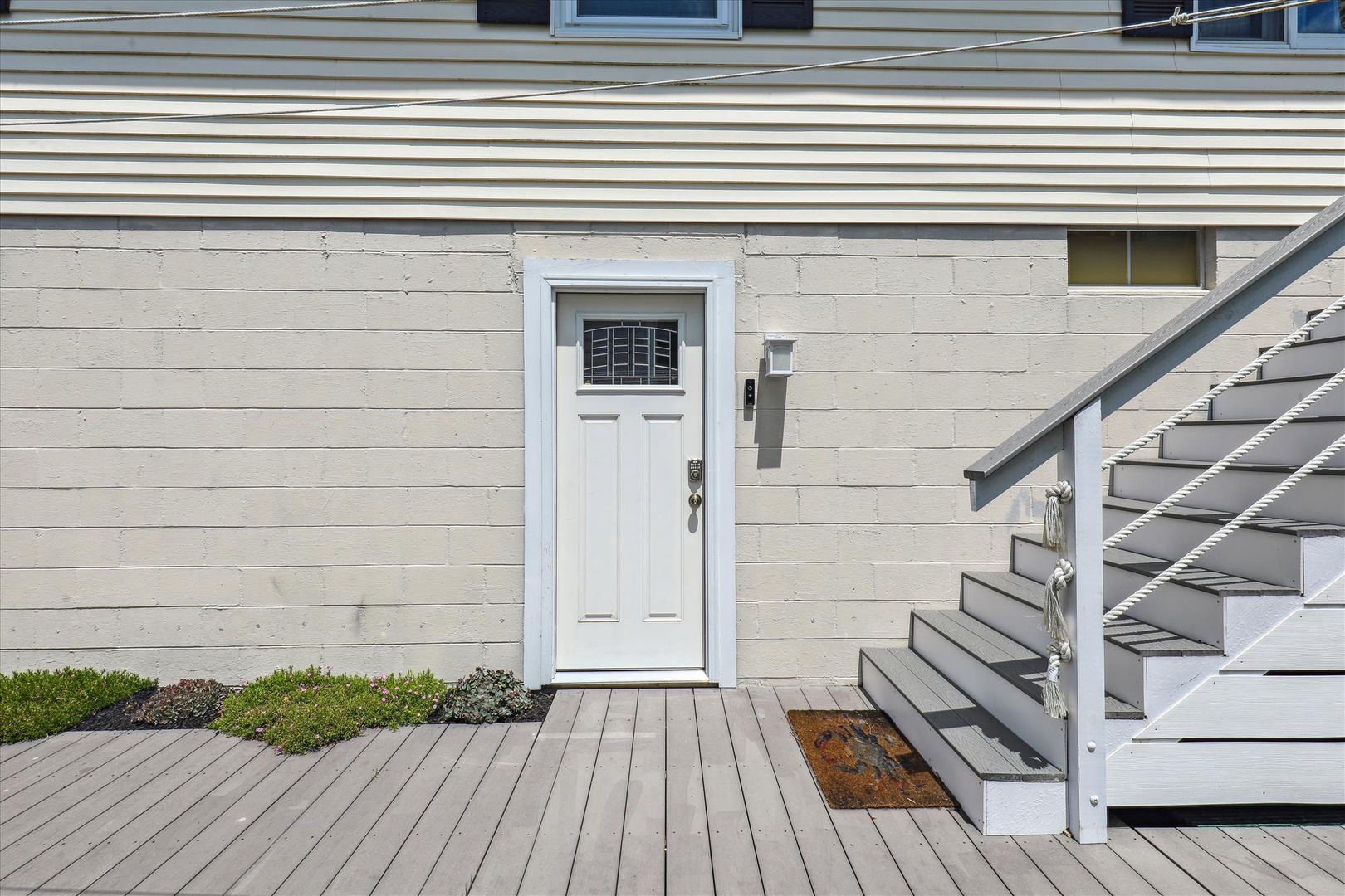 Private entrance with fresh paint and welcoming details marks the start of your coastal retreat.