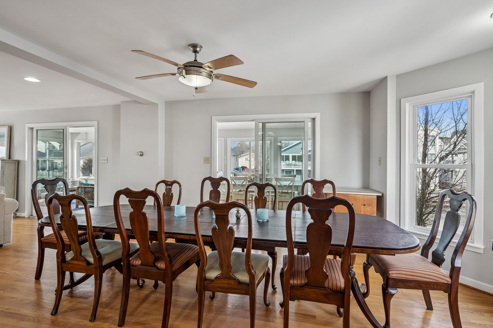 Gather around the elegant dining table for meals together, with warm hardwood floors underfoot and natural light streaming through the windows to create an inviting atmosphere.