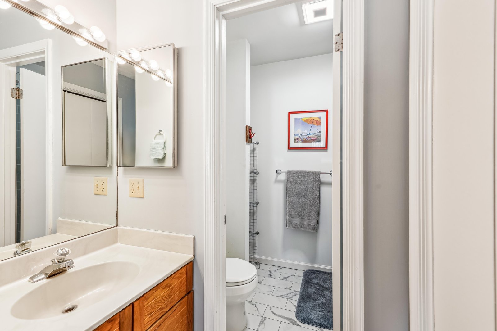 Your private bathroom features warm wood vanity, ample lighting, and fresh towels for your arrival.