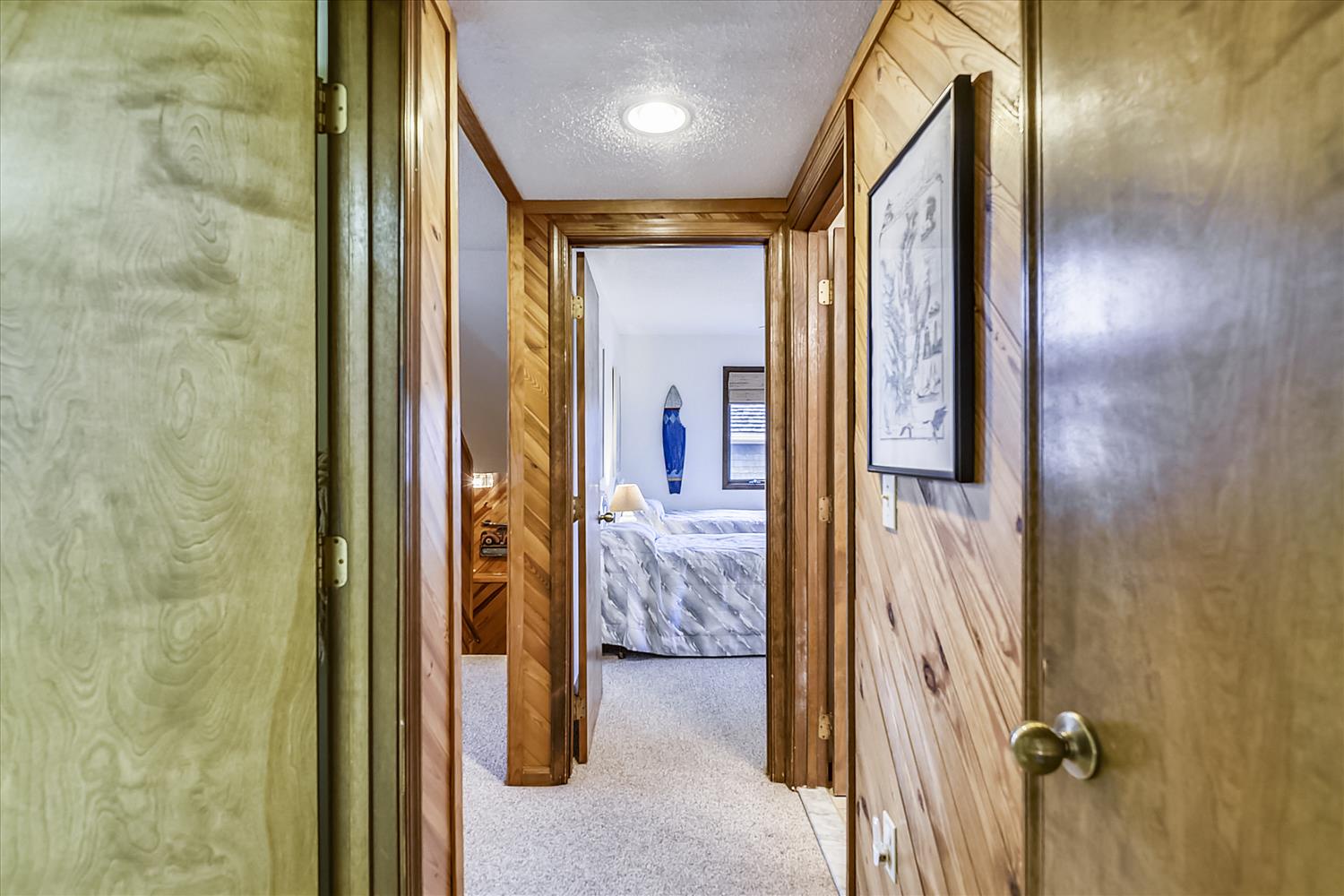 Step through this welcoming hallway where warm wood paneling guides you to your cozy bedroom retreat.