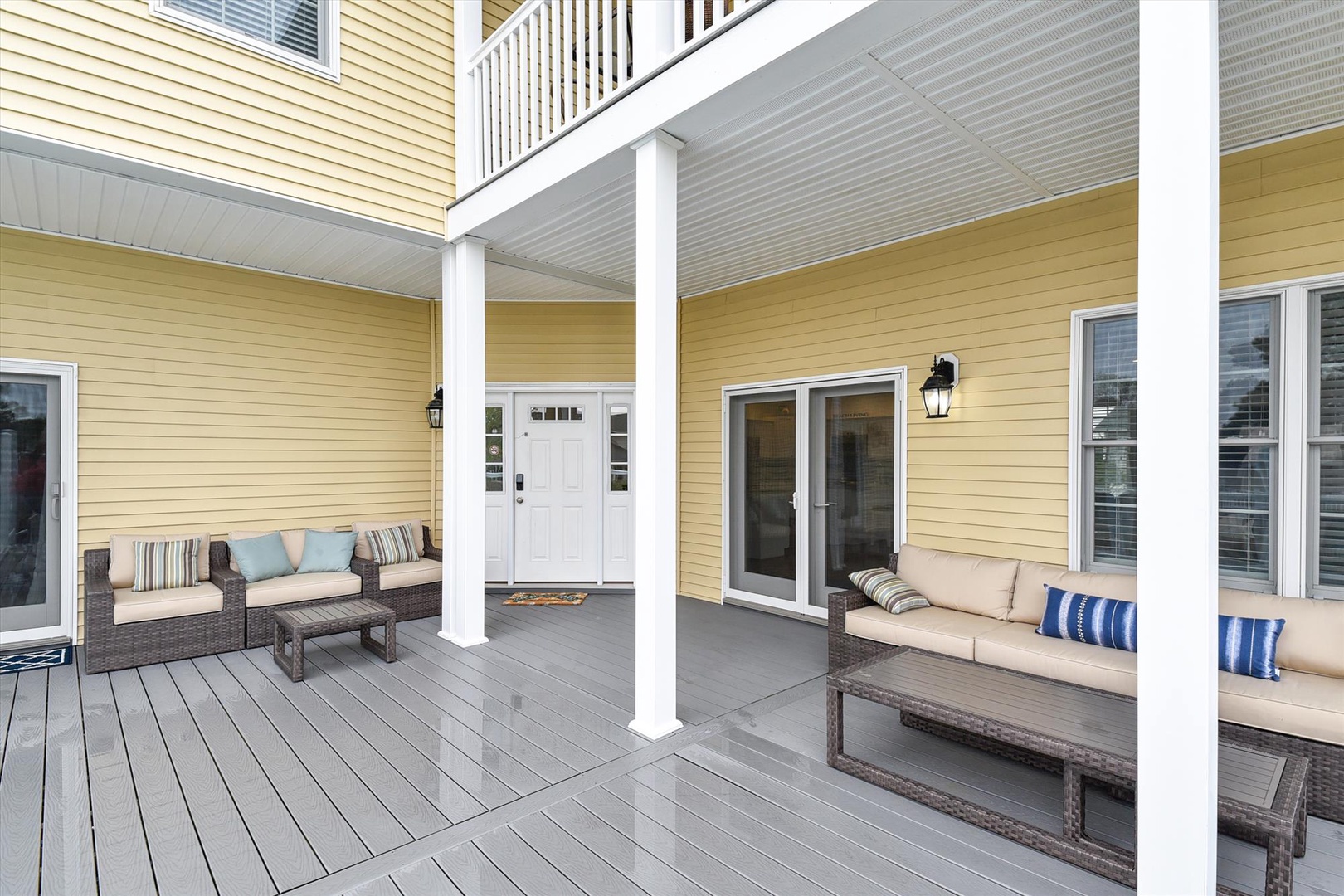 Charming covered porch features comfortable seating areas where you can unwind and enjoy the fresh air. The thoughtful layout creates multiple cozy spots for relaxing outdoors.