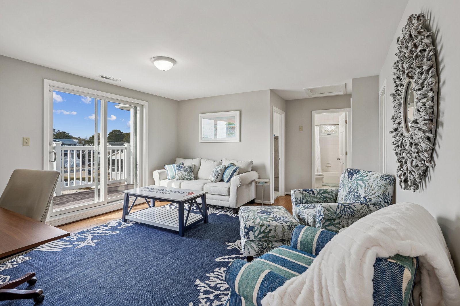 Sink into plush seating and let the soft coastal hues soothe you. Natural light streams through sliding doors, inviting you to your private balcony with serene water views.