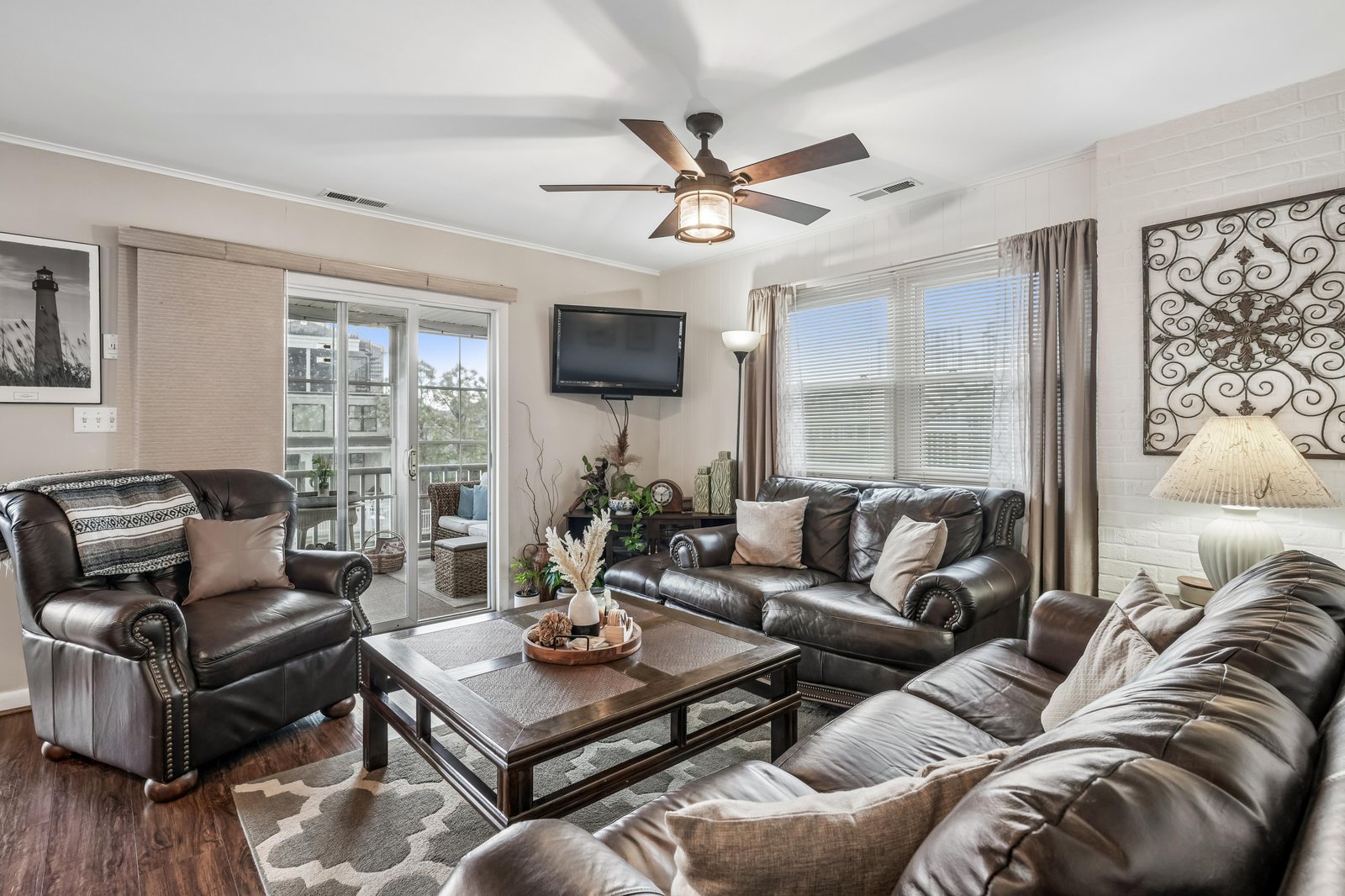 Sink into plush leather seating and enjoy your favorite shows in this bright, beautifully styled living room. Ceiling fan, smart TV, and charming balcony access make relaxation effortless here.