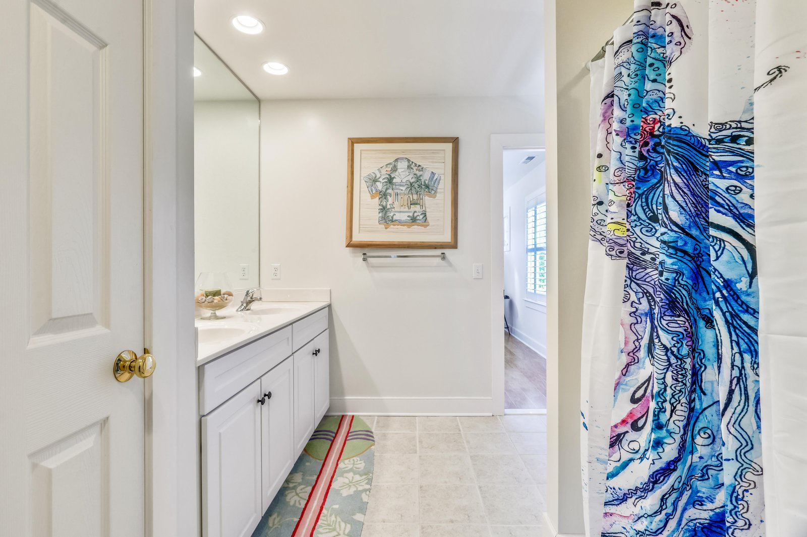 Step into your bright bathroom, where a coastal vibe and natural light create the perfect start to your day. The vanity offers plenty of space for your morning routine, and the walk-in shower awaits to refresh you.