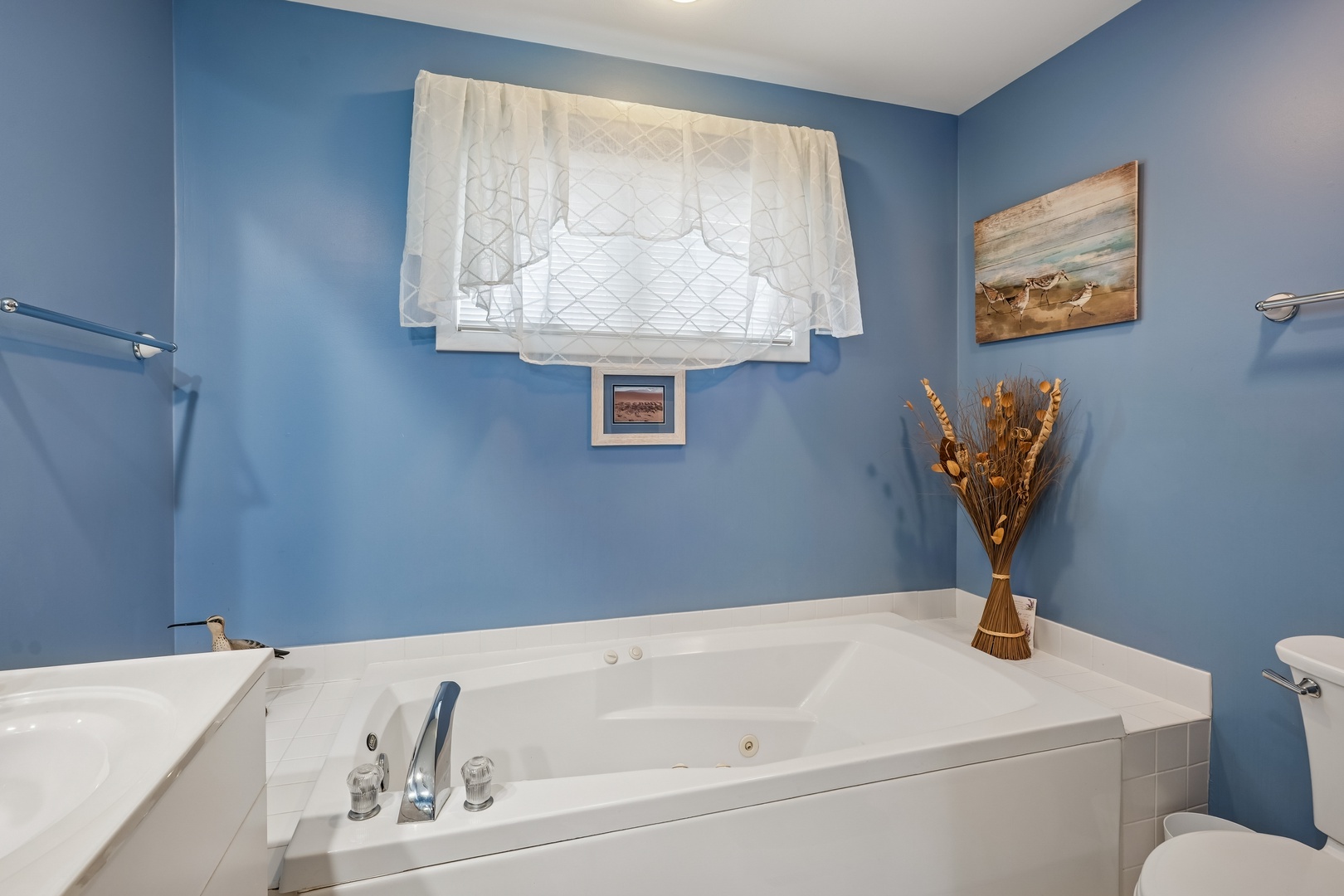 Sink into your private jetted tub surrounded by calming blue walls and charming coastal decor for the perfect relaxing soak.