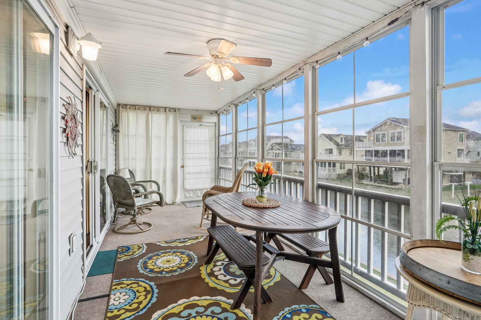 Your private enclosed patio offers comfortable seating and panoramic neighborhood views, perfect for enjoying morning coffee or evening meals surrounded by natural light.