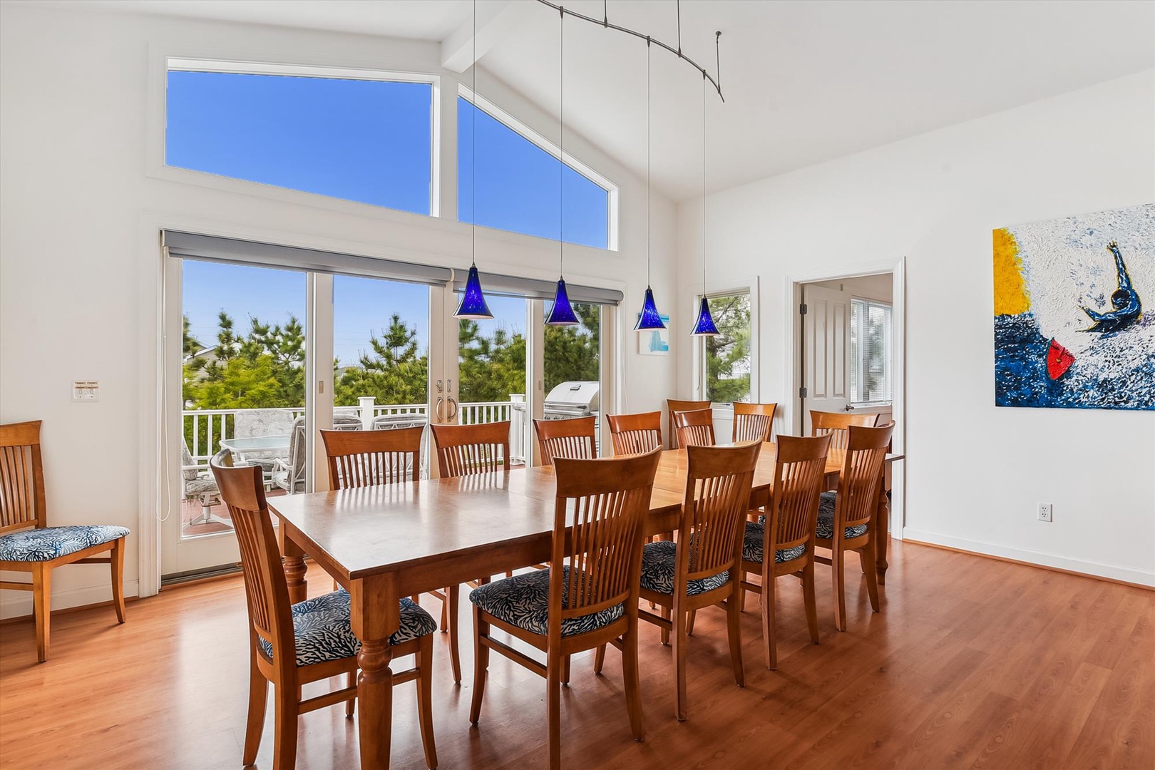 Gather your group around this spacious dining table, where vaulted ceilings and natural light create an inviting atmosphere for memorable meals together, with balcony views adding to the ambiance.