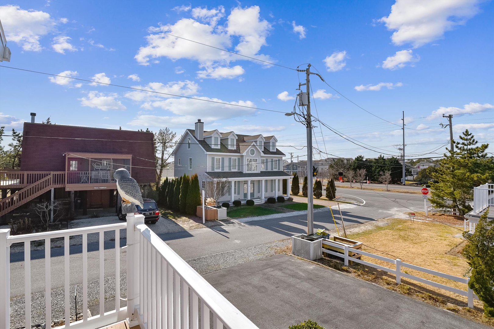 Peaceful residential neighborhood situated near the coast, featuring a quiet street view with spacious homes and mature landscaping under bright blue skies.