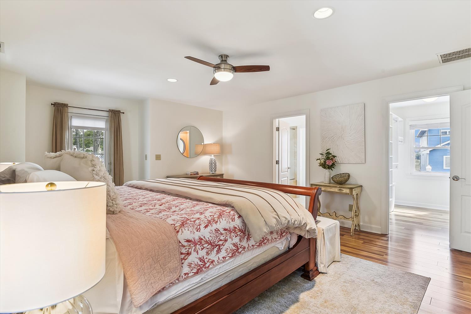 Sink into this inviting bedroom with its plush bedding, warm hardwood floors, and gentle ceiling fan—your peaceful retreat after a day of adventure.