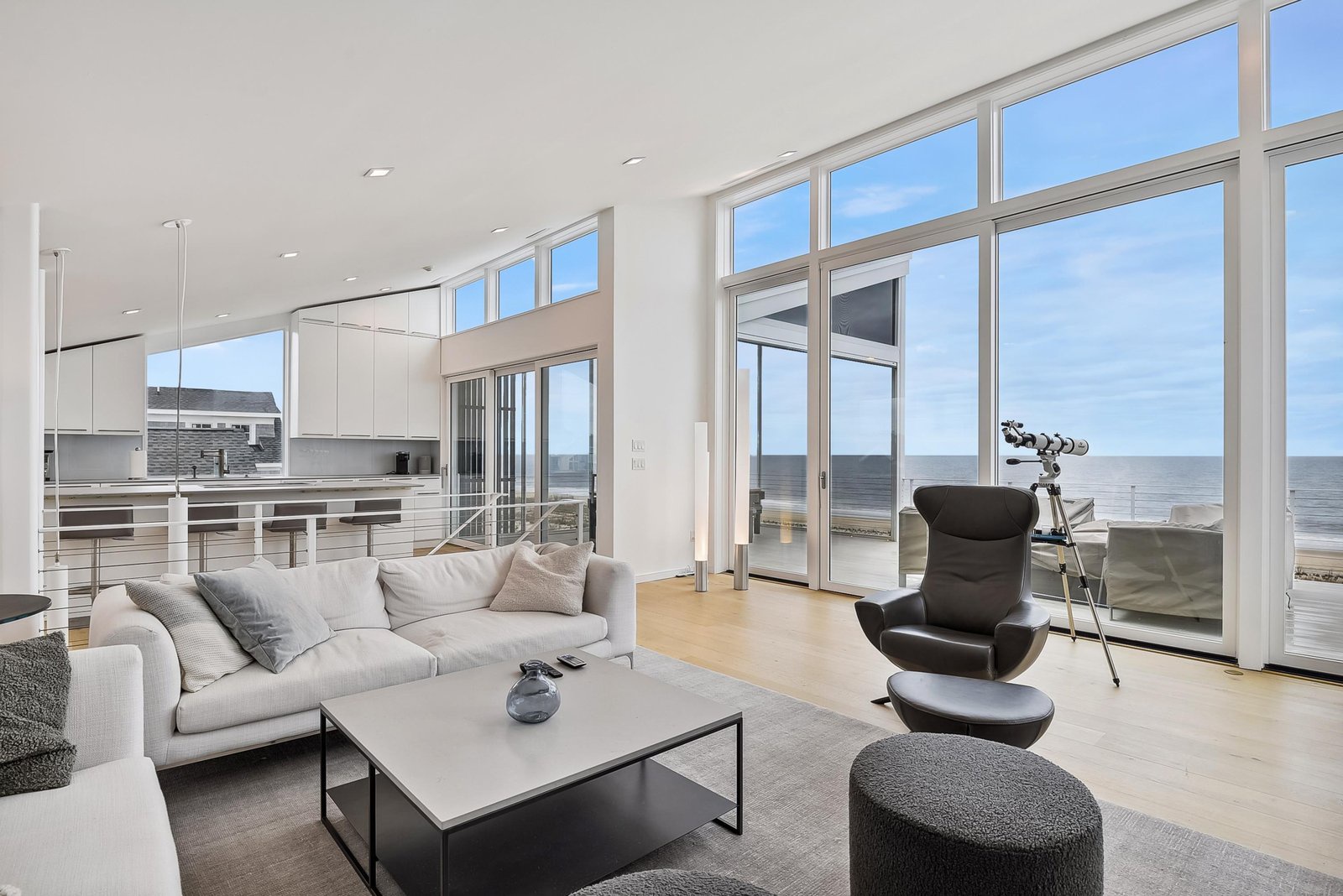 Step into your sunlit sanctuary where floor-to-ceiling windows frame endless ocean views. Settle into the plush sofa or designer lounge chair and watch the waves roll in—your perfect spot to unwind and recharge.