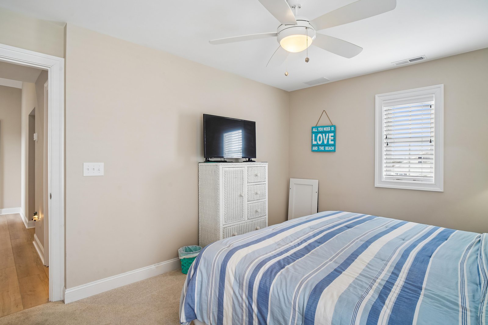 Drift off to sleep under a gentle ceiling fan in your bright, beachy bedroom with coastal charm and all the comforts of home waiting for you.