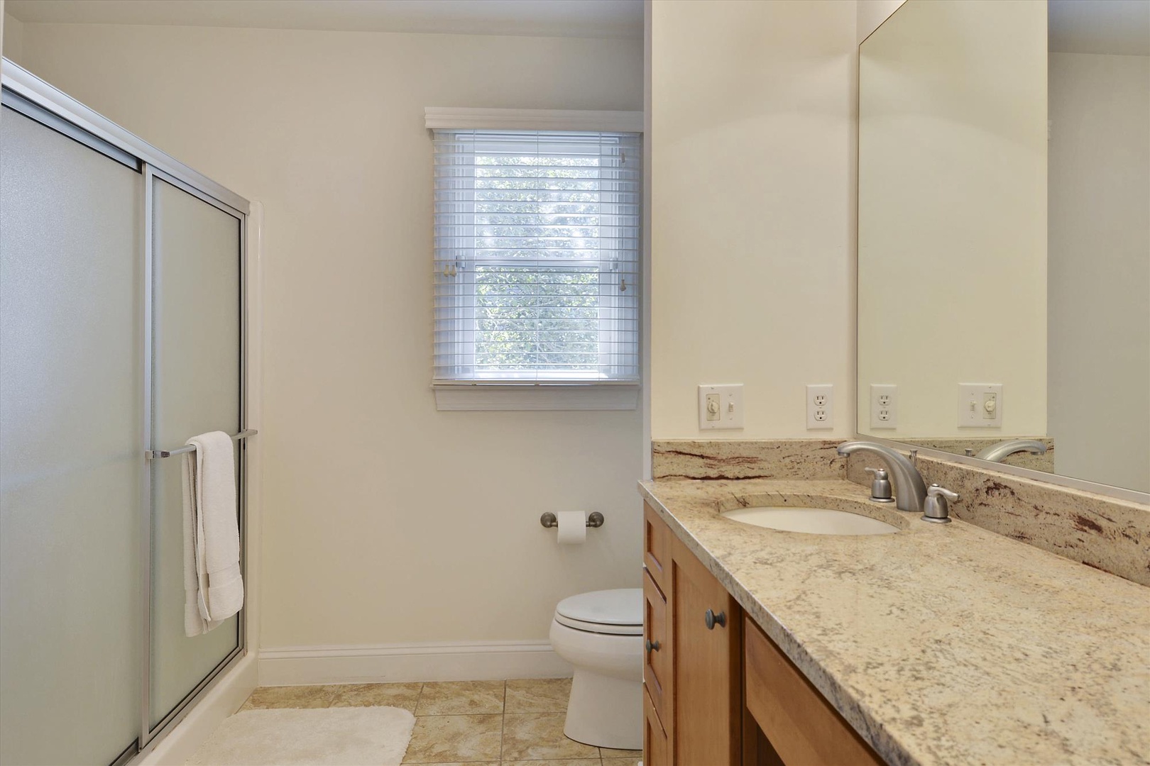 Your private bathroom features granite countertops, walk-in shower, and natural light creating a serene space to refresh.