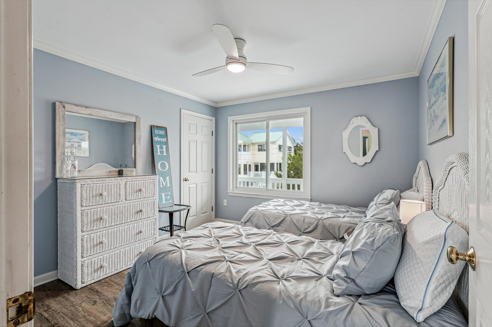 Drift off to sleep in this serene coastal bedroom, where soft blue walls and fresh white accents create a calming retreat after a day of beachside adventures.