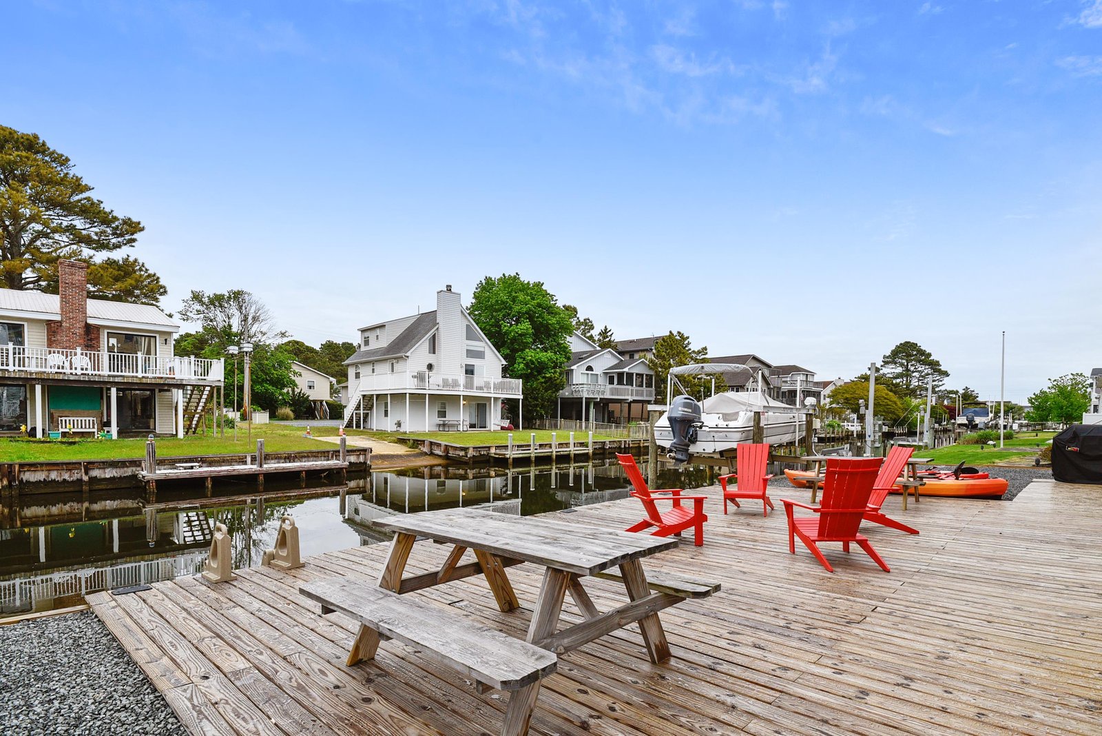 Relax in bright red Adirondack chairs on your private dock, where calm waters and a picnic table invite you to unwind with waterfront views all day long.