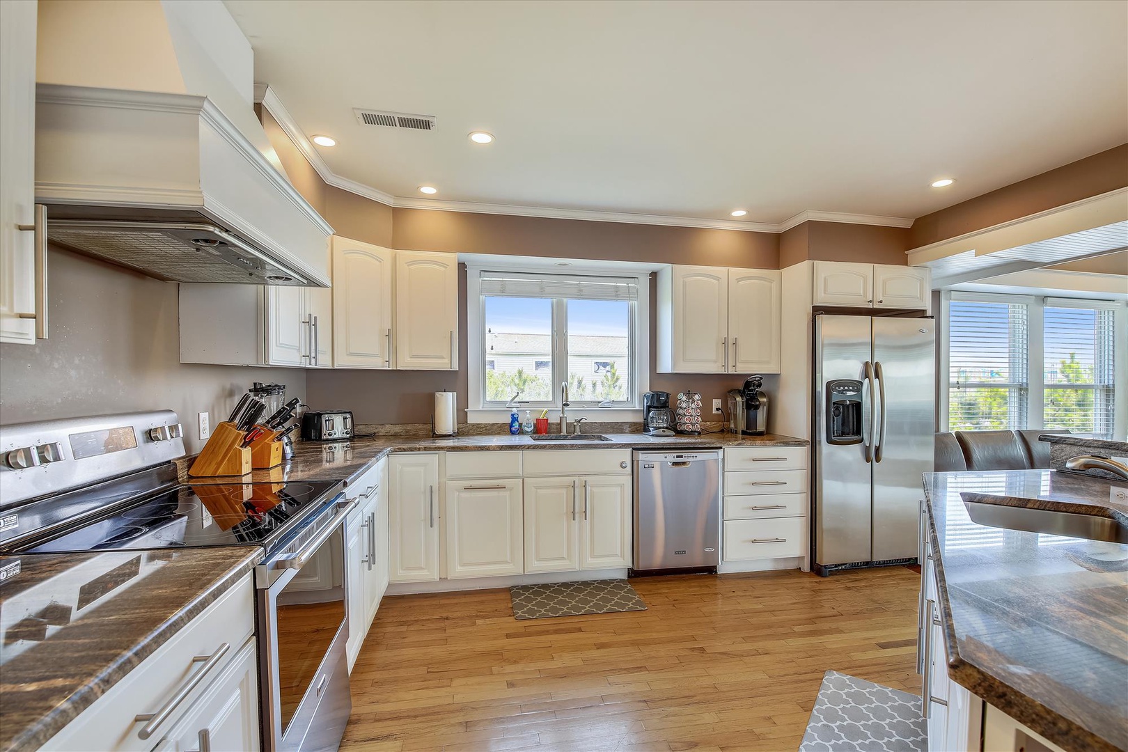 Your gourmet kitchen awaits with gleaming stainless steel appliances, expansive granite countertops, and abundant natural light streaming through oversized windows—perfect for preparing memorable meals during your stay.