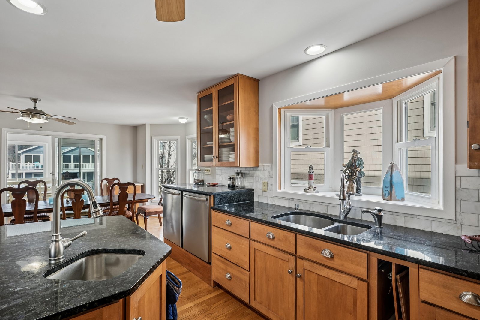 This well-appointed kitchen features granite counters, stainless appliances, and warm wood cabinetry—perfect for preparing your favorite meals while natural light pours in through large windows.