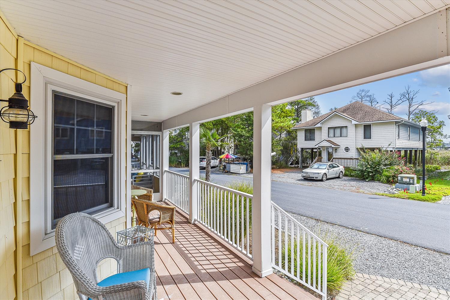 A covered front porch with comfortable seating offers views of the neighborhood and nearby homes.